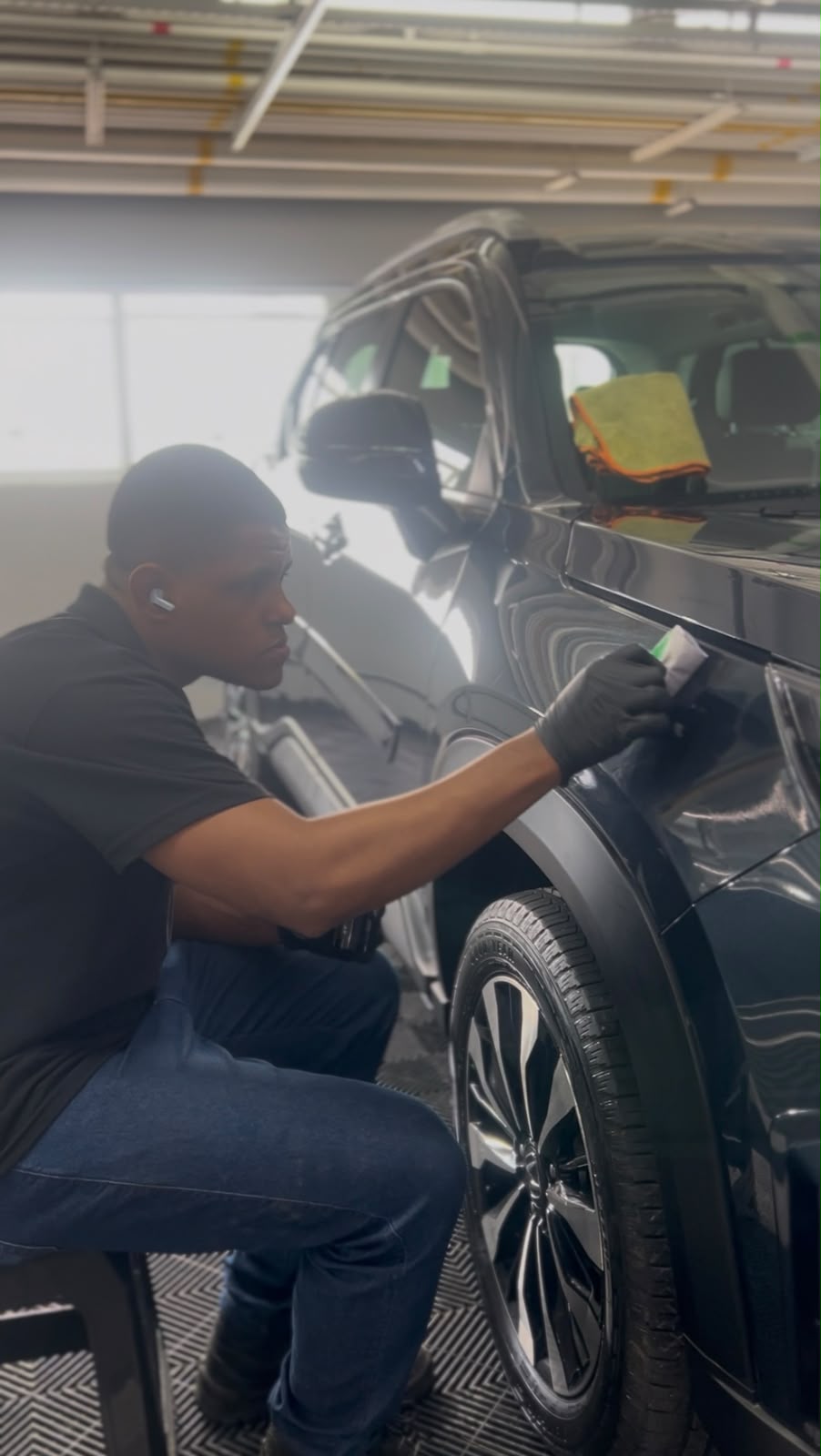 Aplicação de cera no capô de um carro escuro na Geral Biolavagem
